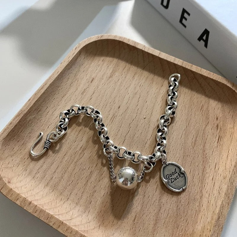 Silver bracelet with charms on a wooden tray