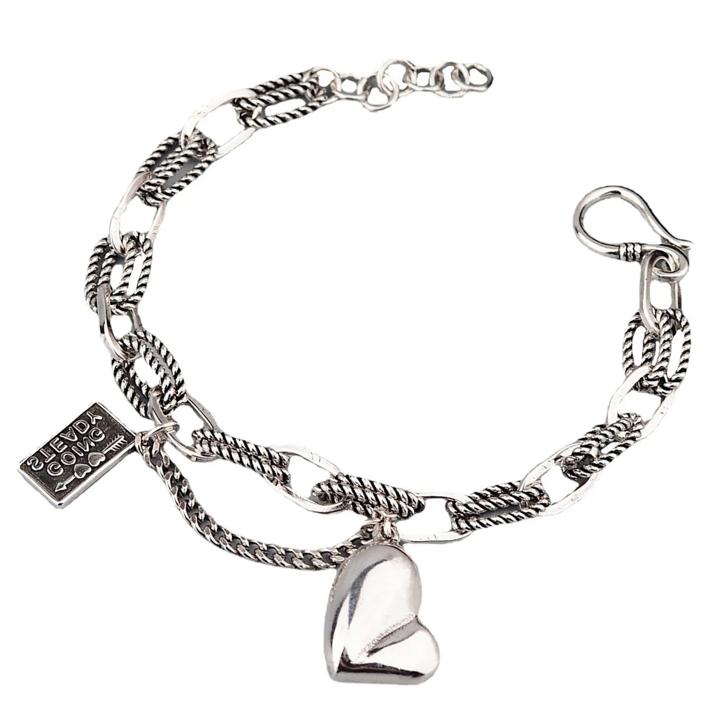 Silver bracelet with heart charm and tag on a white background