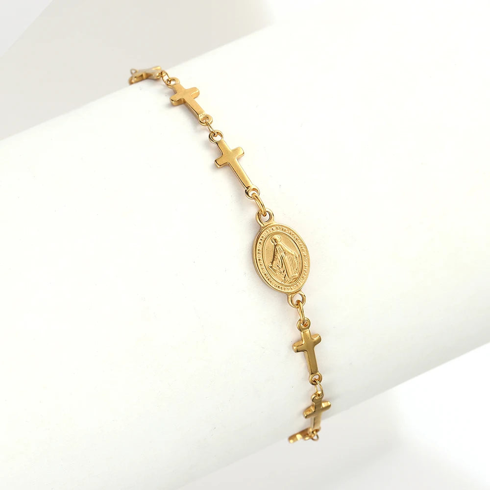 Gold bracelet with crosses and a central medallion on a white background