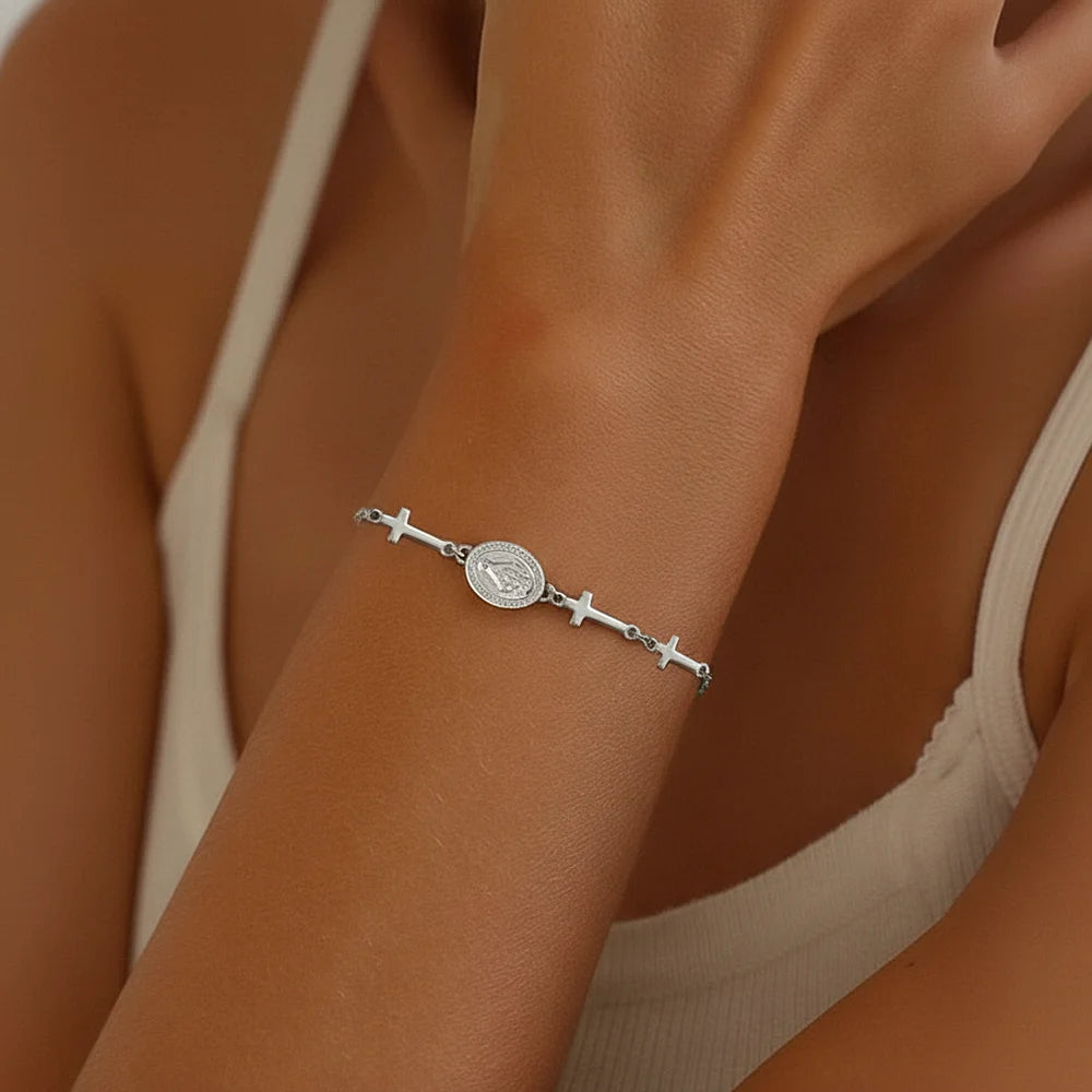 Silver bracelet with cross designs on a person's wrist