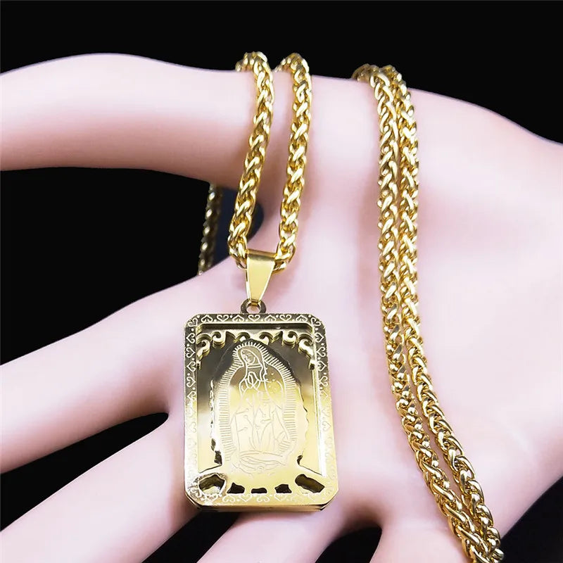 Gold necklace with a rectangular pendant on a hand against a black background