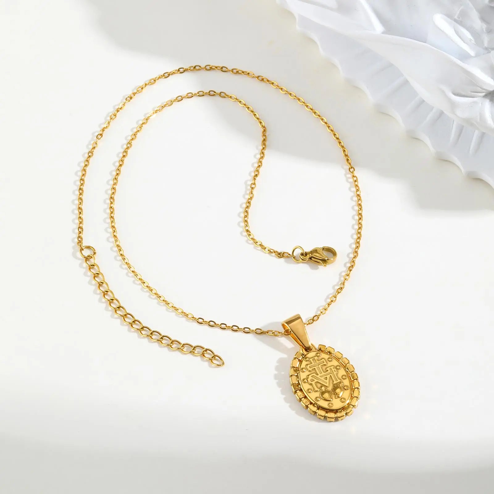 Gold necklace with a pendant on a white background